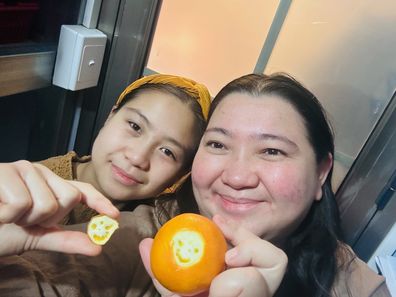mother and daughter smiling orange 