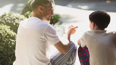 Father with coffee talking to son on front stoop parent conversation children 