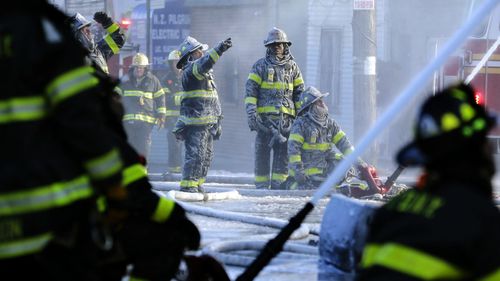 Firefighters in New York are coated in ice as water from their fire engine freezes on their uniforms. (AAP)