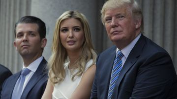 Donald Trump, right, sits with his children, from left, Eric Trump, Donald Trump Jr., and Ivanka Trump during a ground breaking ceremony for the Trump International Hotel in Washington, July 23, 2014. 