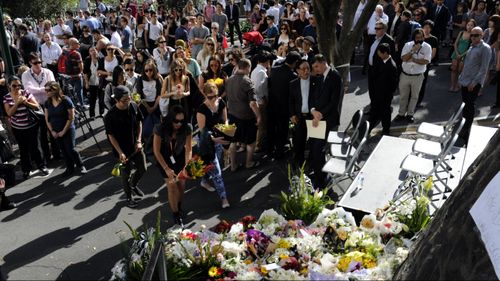 Mourners place flowers during Ms Ban's memorial service. Picture: AAP