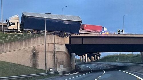 Truck hangs off edge of bridge after crash on English motorway