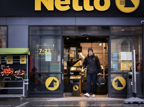 A customer walks out of a supermarket in Copenhagen, Denmark on Tuesday February.  1, 2022. 