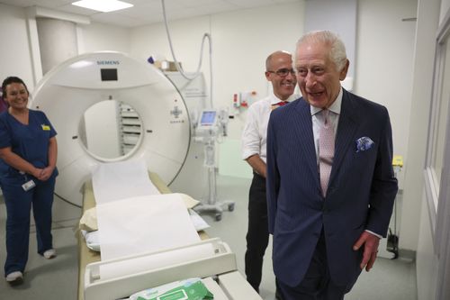 Britain's King Charles III and Cancer Research UK's Chief Clinician, Charlie Swanton react next to a CT scanner during a visit to the University College Hospital Macmillan Cancer Centre in London, Tuesday April 30, 2024 
