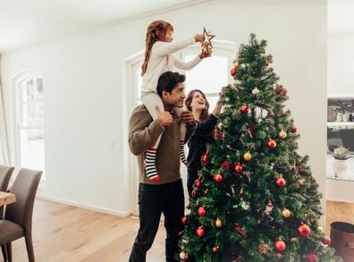 Family decorating a Christmas tree. 