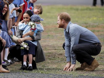 Prince Harry and Meghan, Duchess of Sussex, are hugged by Luke Vincent, 5, upon their arrival in Dubbo, Australia, Wednesday, October 17, 2018. 