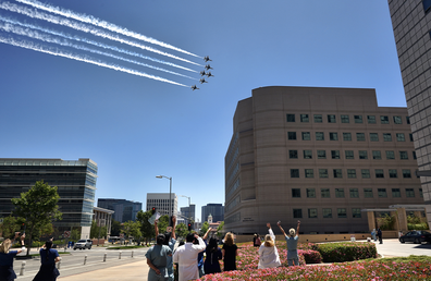 Doctors, nurses and other staff members at the Ronald Reagan UCLA Medical Center watch as the U.S. Air Force Thunderbirds fly over to honor first responders, doctors and nurses in the Westwood section of Los Angeles, Friday, May 15, 2020. (AP Photo/Richard Vogel)