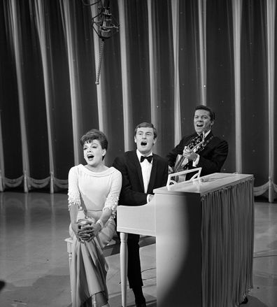 Judy Garland performs with The Allen Brothers (Peter Allen and Chris Bell) in 1965. Peter Allen plays piano. Chris Bell plays guitar.