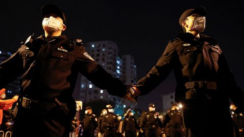Gli agenti di polizia fanno la guardia durante una protesta a Pechino