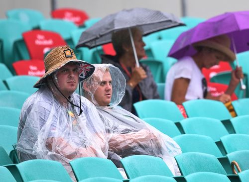 Spectators sit in the stands during rainfall on day one of the fifth test. (AAP)