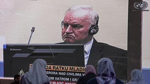 Women from Srebrenica watch a live broadcast from the Yugoslav War Crimes Tribunal in The Hague to learn the verdict for Bosnian Serb military chief Ratko Mladic, on the screen, at the memorial cemetery in Potocari near Srebrenica, eastern Bosnia.