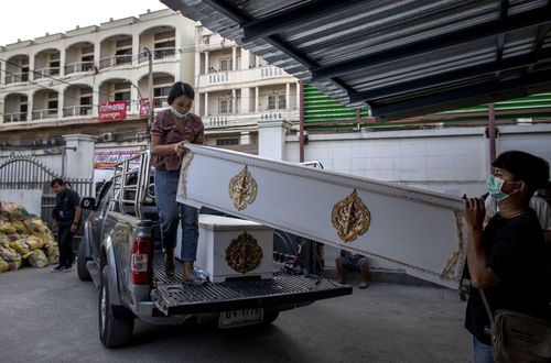Morgue staff carry in coffins in Korat, Nakhon Ratchasima, Thailand