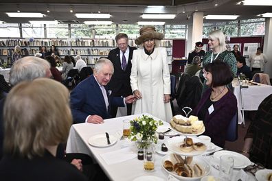 King Charles III, center, and Camilla, the Queen Consort meets volunteers and service users of the charity organisation Age UK, during an afternoon tea at the Colchester Library, in Colchester, England, Tuesday March 7, 2023