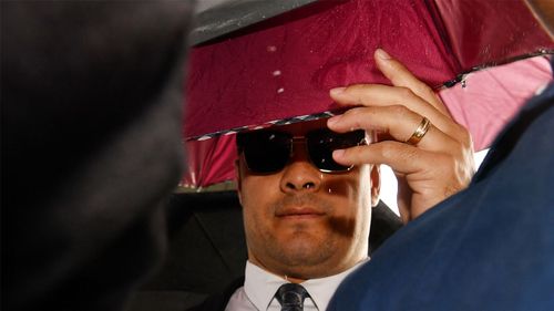 Jarryd Hayne was shielded by umbrellas when he arrived at Newcastle District Court today.