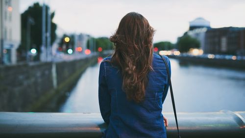 Rearview shot of an unrecognizable young woman taking in the city views while standing on a bridge