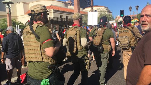 Heavily armed members of the John Brown Gun Club, with anti-Trump protestors. (9NEWS/Lizzie Pearl)