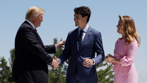 Despite the drama, Trump and Trudeau had a cordial greeting today, shaking hands and smiling for photographers on the lawn outside the resort overlooking the St Lawrence River. Picture: AP
