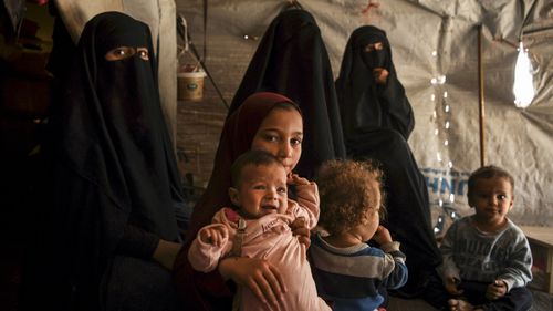 Australian Maysa Assaad, aged nine, holds Shayma Assaad's daughter Mariam in al-Hawl camp.