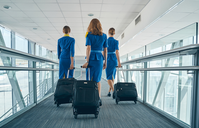 Flight attendants walking with a suitcase / luggage