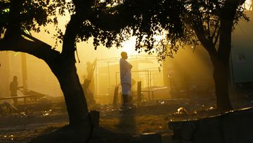 A man stands in the early morning sun on the dusty streets of Lusaka, the capital city of Zambia.