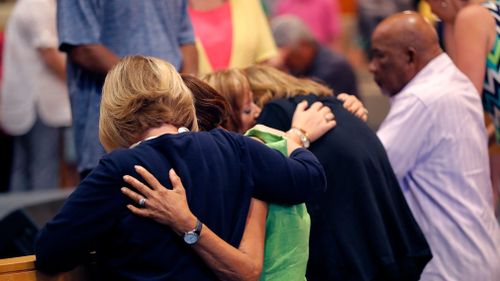 People embrace during a service at the First United Methodist Church in Coral Springs, Florida. (AAP)