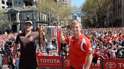 Hawthorn captain Luke Hodge holds the 2014 AFL Premiership Cup with Sydney Swans captain Kieren Jack. (AAP)