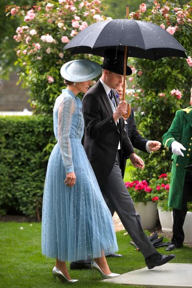 Prince William and Kate Middleton shelter under an umbrella at Royal Ascot