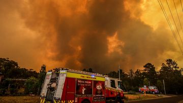 Firemen prepare as a bushfire approaches homes on the outskirts of the town of Bargo on December 21, 2019 in Sydney, Australia.