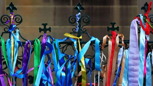 Rainbow ribbons attached to the gates outside the church.