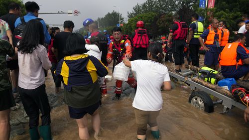 Volunteers distribute foods to rescuers before they send them to flood trapped residents, in Zhuozhou in northern China's Hebei province, south of Beijing, Wednesday, Aug. 2, 2023. China's capital has recorded its heaviest rainfall in at least 140 years over the past few days. Among the hardest hit areas is Zhuozhou, a small city that borders Beijing's southwest. (AP Photo/Andy Wong)