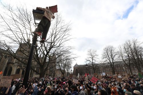 A protester climbs a lamp post as people take part in a 'Kill the Bill' protest in College Green