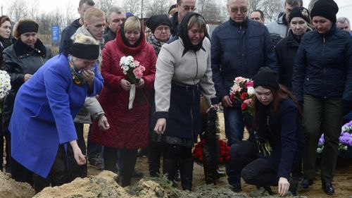 People grieve at the grave of Irina Medyantseva, 50, a victim of the blast at Saint Petersburg metro. (AFP)