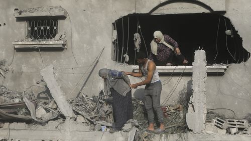 Palestinians evacuate a building damaged in the Israeli bombardment of the Gaza Strip in Rafah.