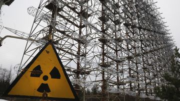 A Soviet-era top secret object Duga, an over-the-horizon radar system once used as part of the Soviet missile defense early-warning radar network, seen behind a radioactivity sign in Chernobyl, Ukraine, on Nov. 22, 2018. 