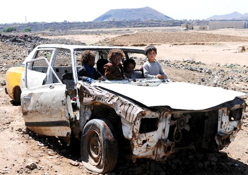 Displaced Yemeni children who with their families fled homes due to the Yemen civil war enjoy riding a damaged car at the outskirts of Sana'a, Yemen. More than three million people fled their homes since the war erupted on March 2015. (Getty)