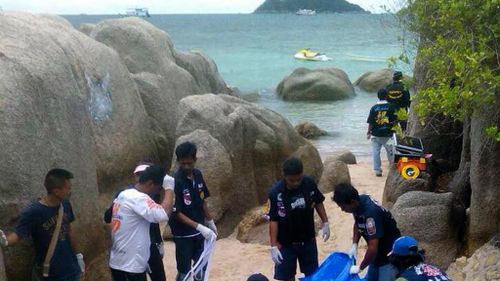 Thai rescue workers wrap the bodies of two British tourists who were found dead on a beach of Koh Tao island, Surat Thani province, southern Thailand. (AAP)