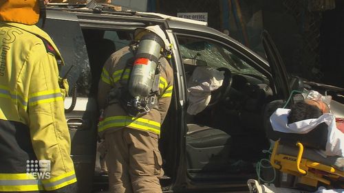 Emergency workers treat the driver at the scene of the crash in Adelaide.