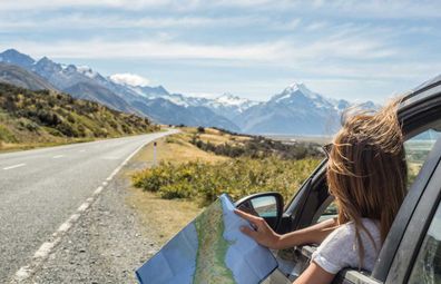 Woman checking paper map on a highway