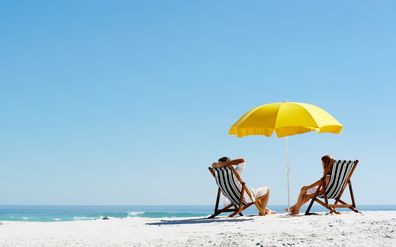 beach umbrella. couple at the beach. people at the beach.