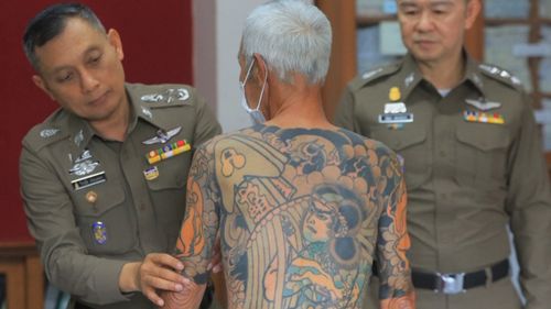 Mr Shirai's intricate tattoos were spotted in a photo of him sitting at a checkers table in August 2017, which ultimately led to his arrest (AP).