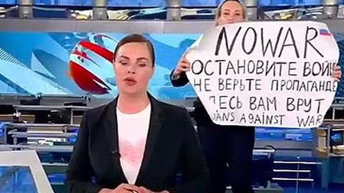 Marina Ovsyannikova holding protest sign behind Russian newsreader (supplied)