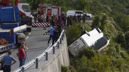 Rescue workers remove a bus at the accident site on a road near Cetinje, Montenegro.