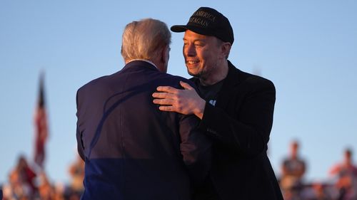 Republican presidential nominee former President Donald Trump hugs Elon Musk at a campaign rally at the Butler Farm Show, Saturday, Oct. 5, 2024, in Butler, Pa. 