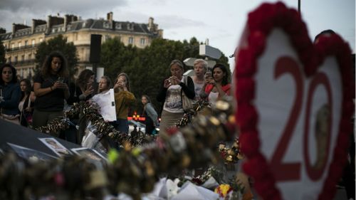 People take photographs as they pay tribute to the late Princess Diana above the Pont de l'Alma tunnel where she died. (AAP)