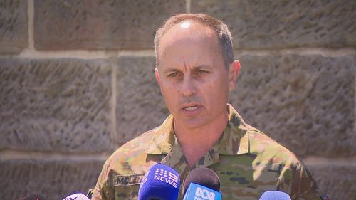 Brigadier Ben McLennan speaking at a press conference in his uniform.
