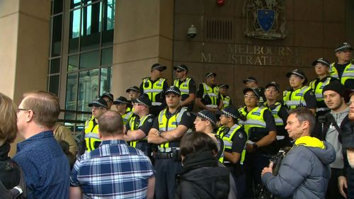 Officers line the steps of the Melbourne Magistrates' Court ahead of Cardinal Pell's arrival. 