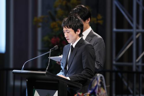 Junpei Kanno talks about the loss of his brother Yosuke at a public memorial service in the Melbourne Royal Exhibition building in 2018.