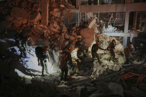 Israeli security forces inspect a destroyed building that was hit by a missile fired from Iran, near Tel Aviv