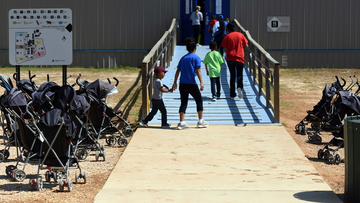 FILE -In this Aug. 9, 2018, file photo, provided by U.S. Immigration and Customs Enforcement, immigrants walk into a building at South Texas Family Residential Center in Dilley, Texas.