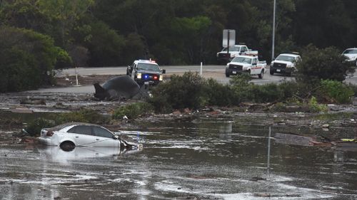 The US 101 Freeway at the Olive Mill Road overpass has been flooded with runoff water from Montecito Creek and blocked with mudflow and debris. (AAP)